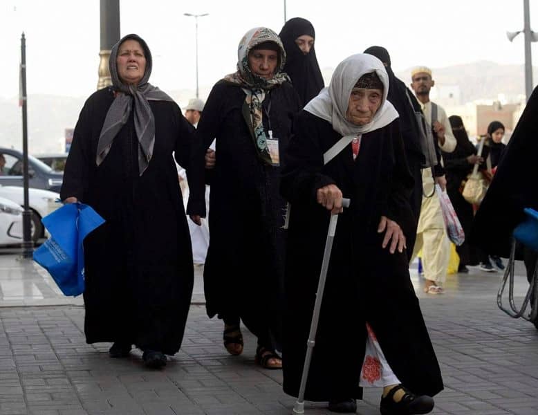عجوز تستند إلى عكازها لزيارة بيت الله