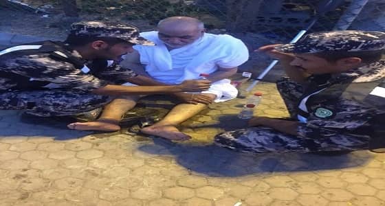 رجلي أمن بالمشاعر المقدسة يساعدان حاجا مسنا أعياه التعب