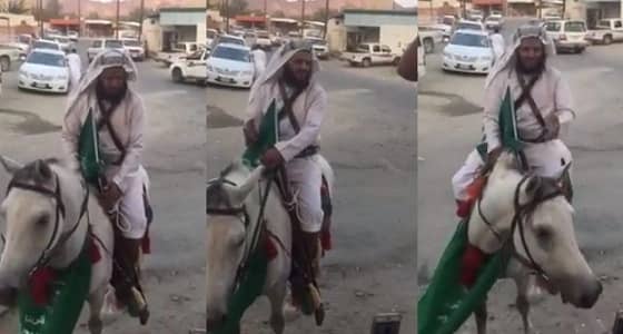 بالفيديو.. " امتطى الجواد وتوشّح بعلم الوطن " .. خيّال يحتفل باليوم الوطني بطريقته