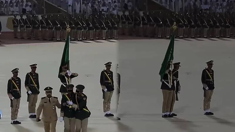 طالب يرفع الراية بيد وبالأخرى يسند زميله المغمى عليه خلال حفل تخريج كلية الملك عبد العزيز الحربية