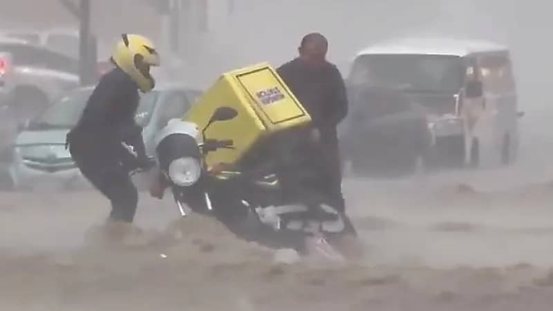 مندوب توصيل يصارع بدراجته النارية السيول.. فيديو