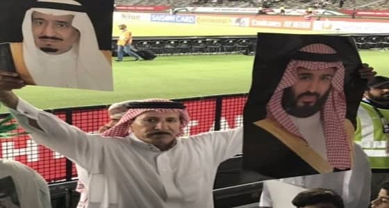 بالصور.. " الفريان " يحمل صورة الملك وولي العهد بمدرجات المنتخب الوطني